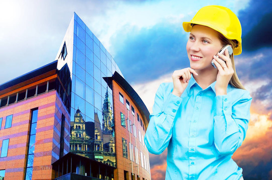站在建筑物背景上的年輕建筑師女士戴著防護(hù)頭盔