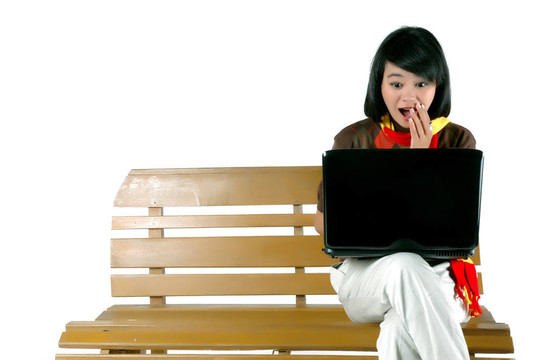 年輕女子驚訝地看著筆記本電腦
