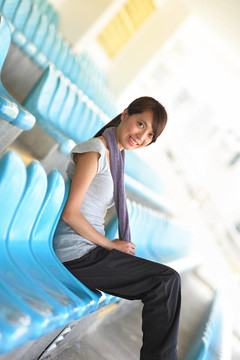 運(yùn)動(dòng)女孩坐在運(yùn)動(dòng)競(jìng)技場(chǎng)