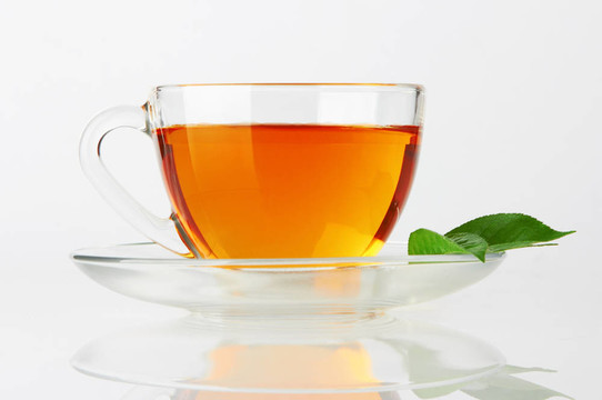 一杯有茶和綠葉的杯子