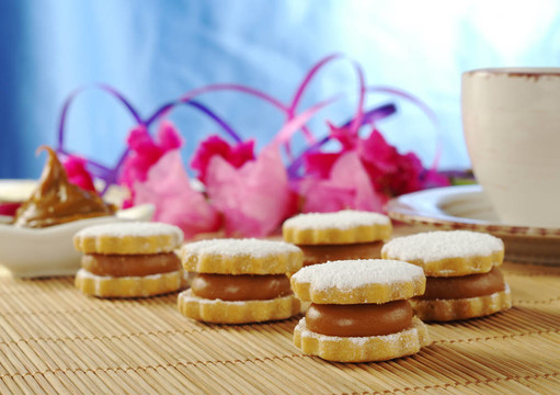 秘魯餅干叫背景中的咖啡和粉紅色的花朵杯墊alfajor（選擇重點(diǎn)）