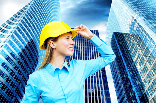 站在建筑物背景上的年輕建筑師女士戴著防護(hù)頭盔