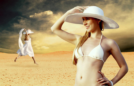 在whitebikini和帽子的年輕漂亮的女人；在陽光明媚的沙漠松弛
