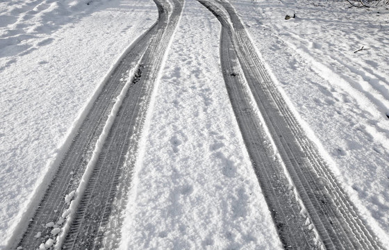 在雪地上的雪地上關閉輪胎痕跡。