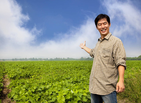 快樂的亞洲農(nóng)民展示他的農(nóng)場