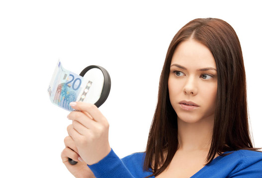 帶放大鏡和歐元現(xiàn)金的婦女