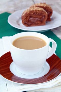 在白色杯子里喝牛奶的茶
