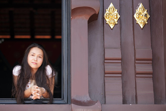 亞洲婦女在寺廟窗口