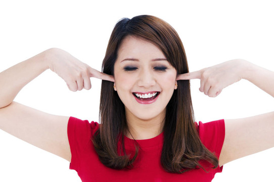 可愛的女人用手指在她的耳朵