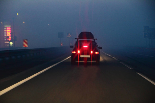 在霧中移動(dòng)的道路上的車(chē)