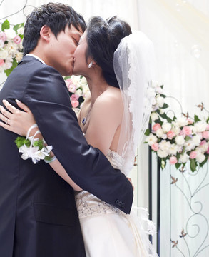一對(duì)年輕夫婦在婚禮上擁抱親吻
