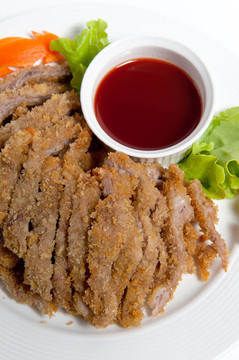 在盤子上用調味醬的豬肉