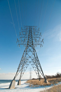 冬季湖旁輸電線路高壓輸電鐵塔。
