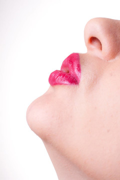 特写工作室肖像年轻女性模型与鲜艳的口红和水滴落在她嘴唇
