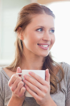 微笑的女人閉上一杯茶