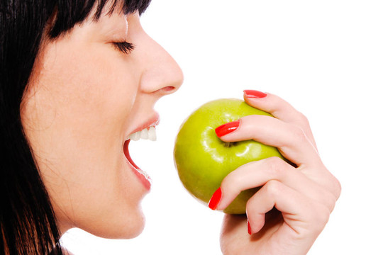 一個(gè)漂亮的年輕女人拿著一個(gè)蘋(píng)果