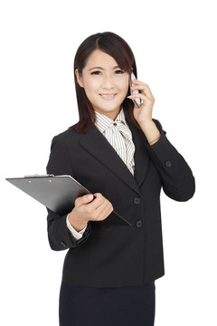 亞洲商業(yè)婦女使用手機(jī)和持有文件夾