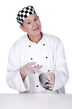 女廚師展示用食指在新鮮的鯛魚(yú)