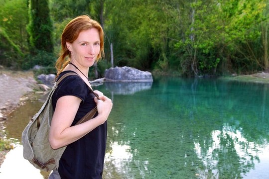 背包徒步旅行者微笑的女人自然河流湖泊