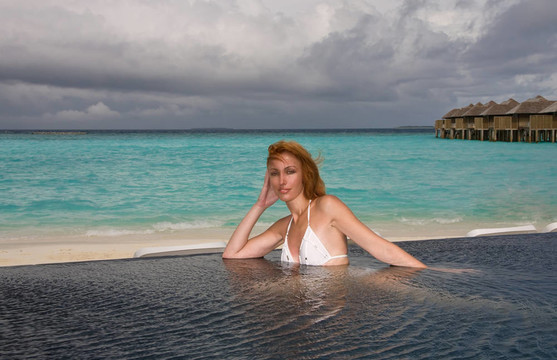 美麗的女人在盆地和海洋的背景。馬爾代夫
