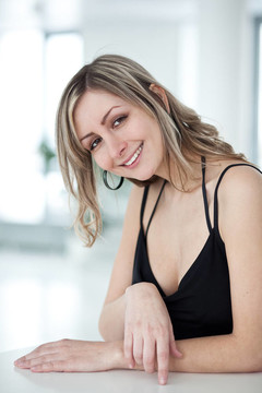 一個穿著漂亮黑色連衣裙的漂亮女人的畫像，微笑著看著你