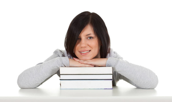 微笑的年輕女人與堆棧的書籍
