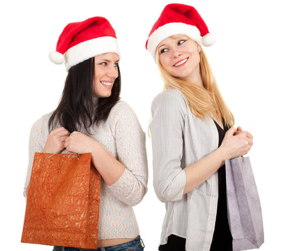 兩個(gè)年輕女子在Santa的帽子與橙色禮品袋