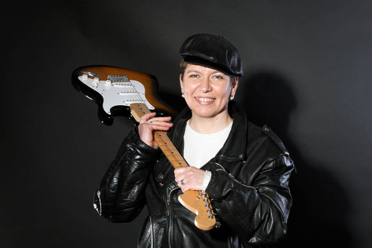 中年婦女用吉他裝扮成搖滾明星