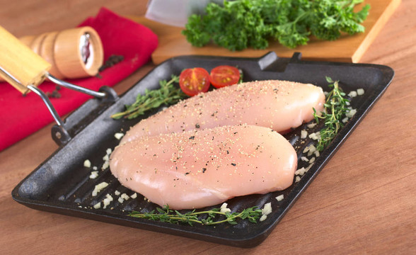 用胡椒調(diào)味油炸鍋的原料雞胸肉；大蒜和百里香新鮮的草本植物，以及在后面的胡椒磨（選擇性聚焦；在肉的前焦