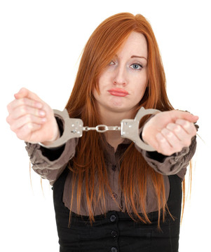 年輕的紅頭發(fā)女人戴手銬的手