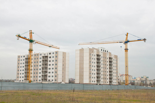 在未完工的公寓樓上方建造起重機(jī)。