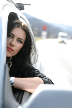 漂亮迷人的女人在汽車；透過窗戶看