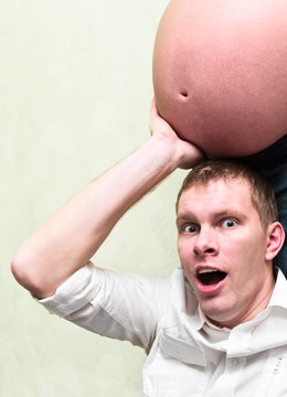 懷著驚喜的孕婦抱著丈夫的雙手。白種人；恩愛的小夫妻