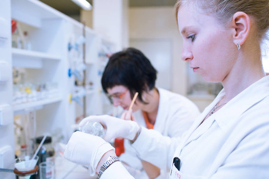 一位女研究員進行的研究在化學實驗室的肖像（顏色色調圖像；淺景深）