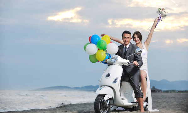 只是夫婦在海灘上騎白色滑板車