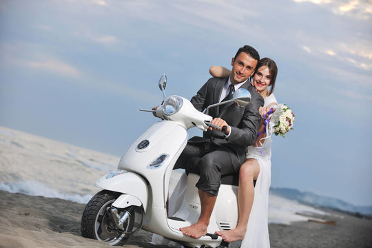 只是夫婦在海灘上騎白色滑板車