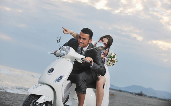 只是夫婦在海灘上騎白色滑板車