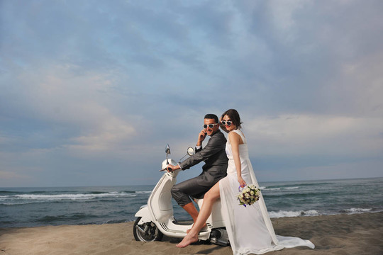 只是夫婦在海灘上騎白色滑板車