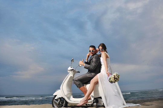 只是夫婦在海灘上騎白色滑板車