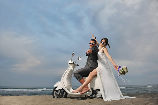 只是夫婦在海灘上騎白色滑板車