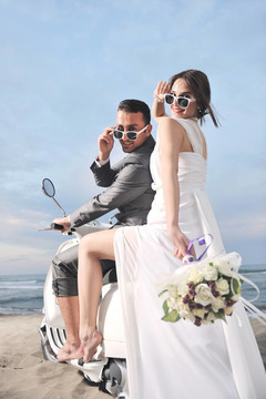 只是夫婦在海灘上騎白色滑板車