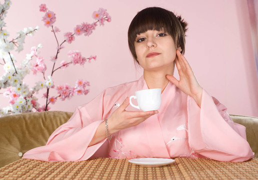 美麗的女孩坐在一個粉紅色的