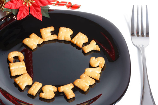 帶餅干的黑色盤子；叉子和圣誕裝飾品