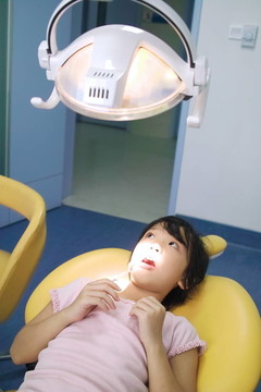 亞洲小孩等待牙齒檢查