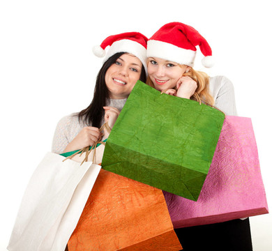 兩個(gè)年輕婦女在Santa的帽子與禮物袋