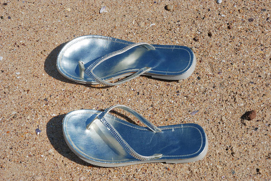 女人在海滩上留下的拖鞋
