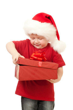 可愛的男孩在Santa帽子打開圣誕禮物在白色的白色隔離盒