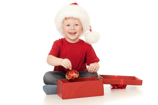 可愛的男孩在Santa帽子打開圣誕禮物在白色的白色隔離盒