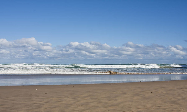 沙滩和波浪的云彩和蓝天晴朗的一天