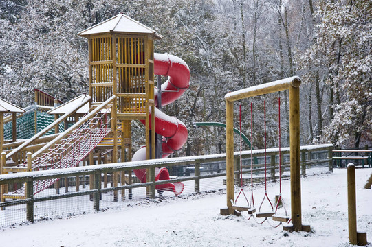在冰雪覆蓋的公園里，空蕩蕩的孩子們的操場(chǎng)上到處都是初雪